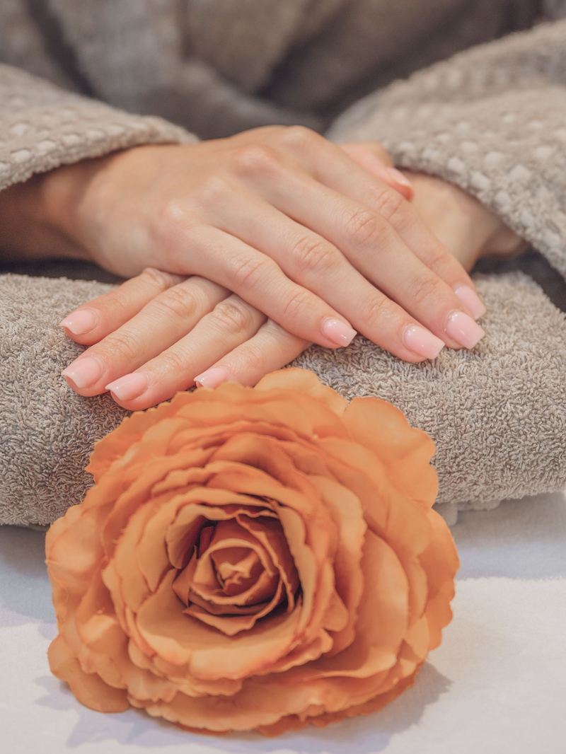 Hands resting on a towel during a spa manicure