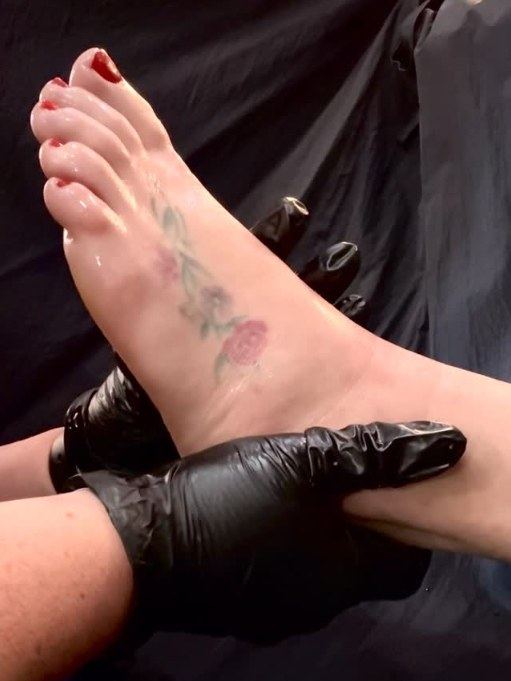 Foot massage during a pedicure, red polish on the toes